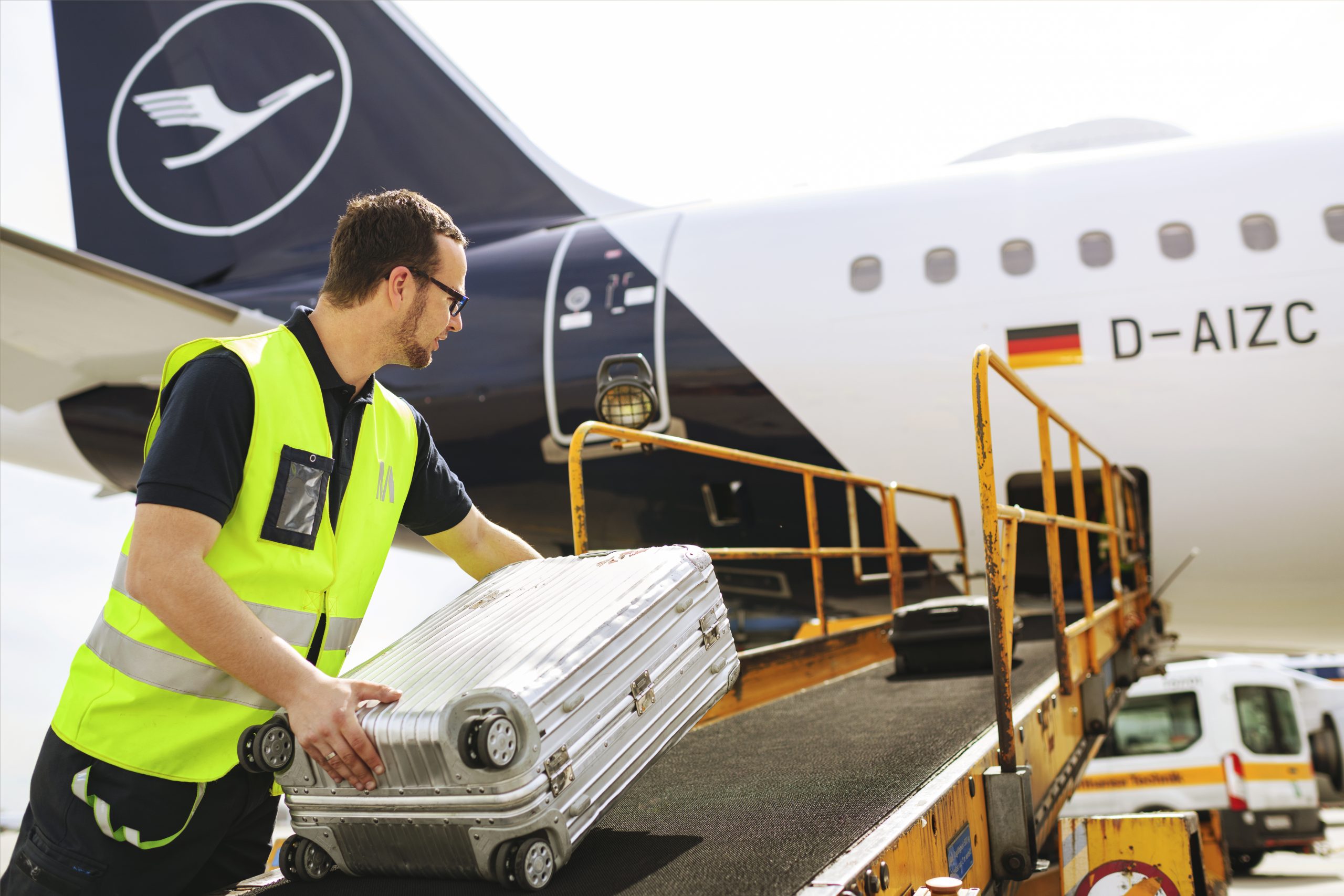 Mitarbeiter belädt Flugzeug am Flughafen München